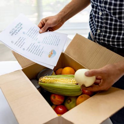 Close-up on a man opening a food subscription box and reading the recipe while looking at the ingredients